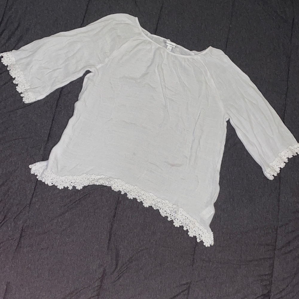 White blouse with the ends of the sleeves outlined with white flower lace